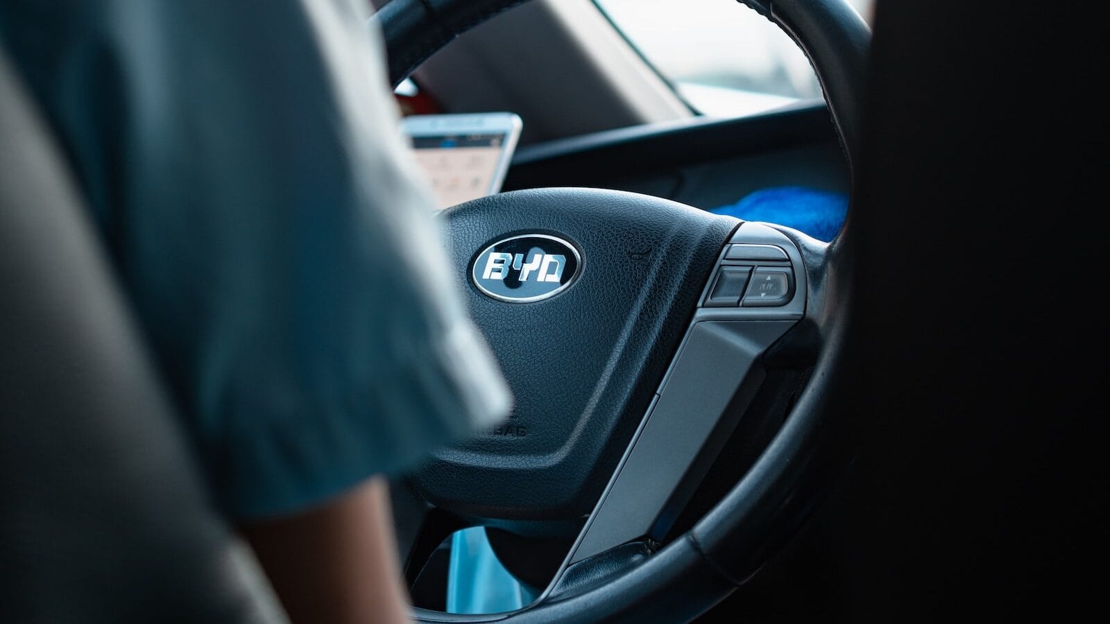 person in blue shirt driving car